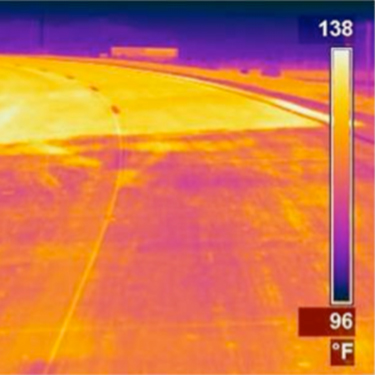 Thermal infrared image of a road with light and dark segments.
